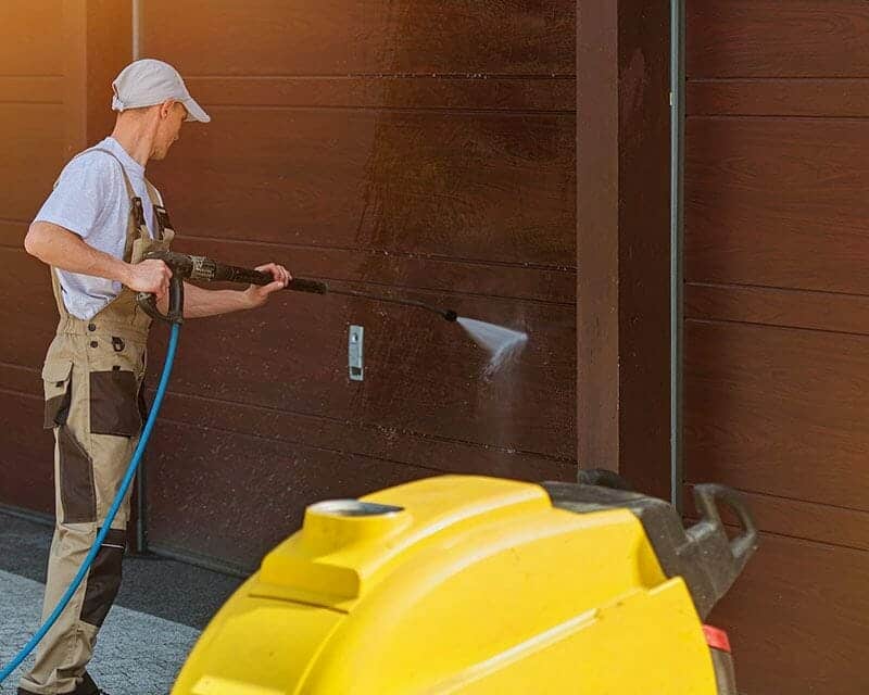 Water blasting removing mould and grime from house exterior