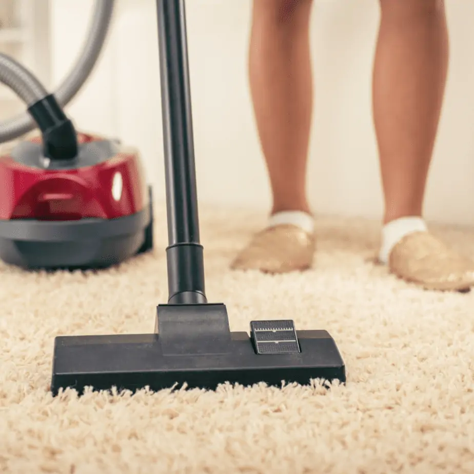 A woman Vacuuming the carpet